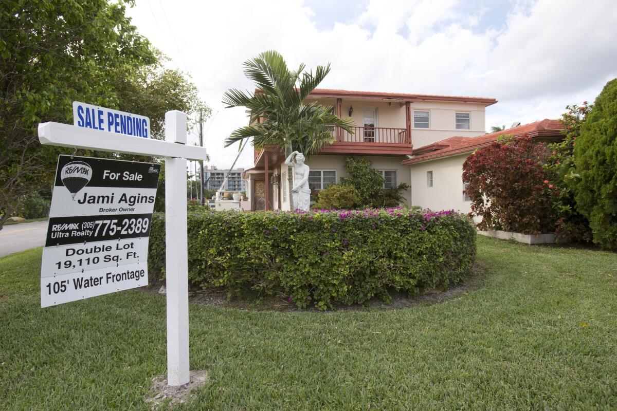 A "sale pending" sign is posted atop a realty sign in front of a home in Surfside, Fla. The National Association of Realtors says pending home sales in January hit 18-month high.
