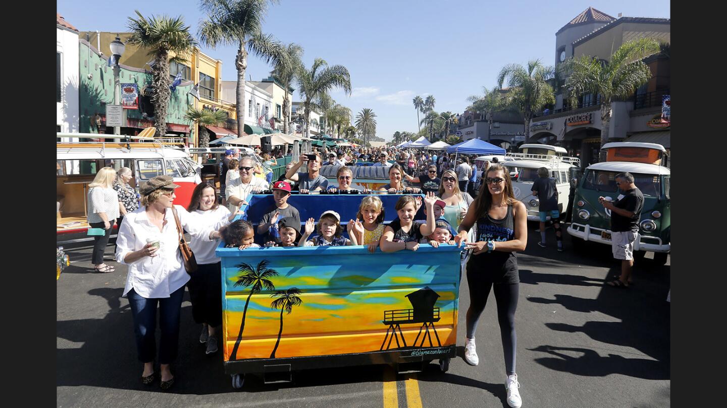 Children ride local artist Laura Svette's creation during the Huntington Beach Public Art Alliance's Dumpsters on Parade and Main Street Art Show event, in Huntington Beach, on Saturday, Oct. 7, 2017. Thirty trash dumpsters were hand painted by local artists and paraded down the first three blocks of Main Street to the delight of many lining the parade route. The dumpsters will be placed around downtown to beautify the area.