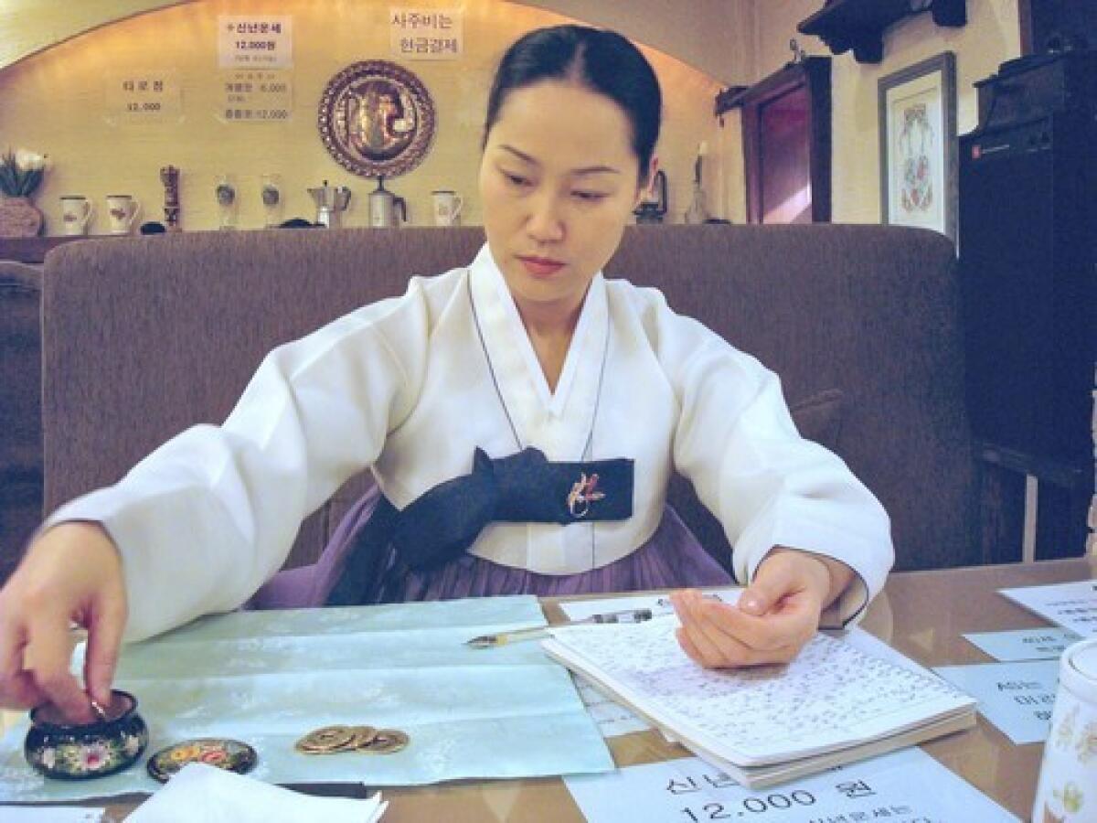 A South Korean fortuneteller who goes by the name Hyunam works on a reading for a customer. Seoul has hundreds of fortunetelling cafes frequented by job seekers.
