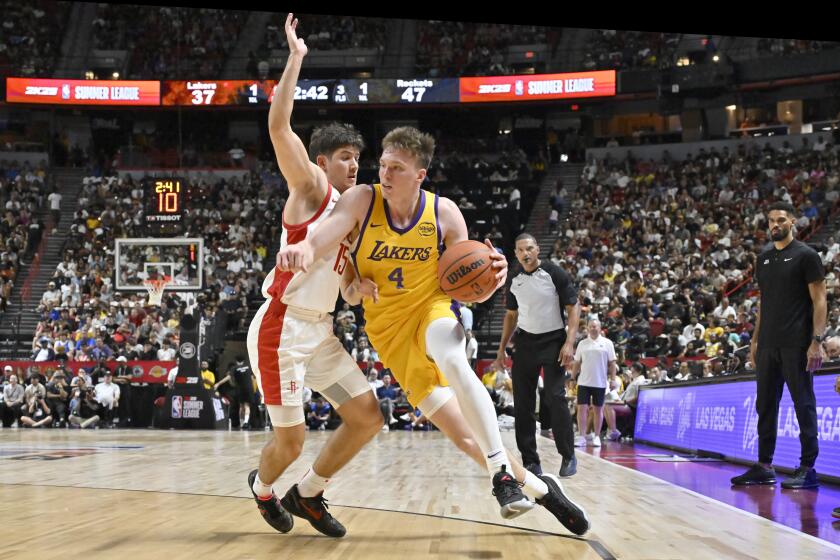 Los Angeles Laker guard Dalton Knecht (4) drives the ball against Houston Rockets guard Reed Sheppard (15) during the first half of an NBA summer league basketball game Friday, July 12, 2024, in Las Vegas. (AP Photo/David Becker)