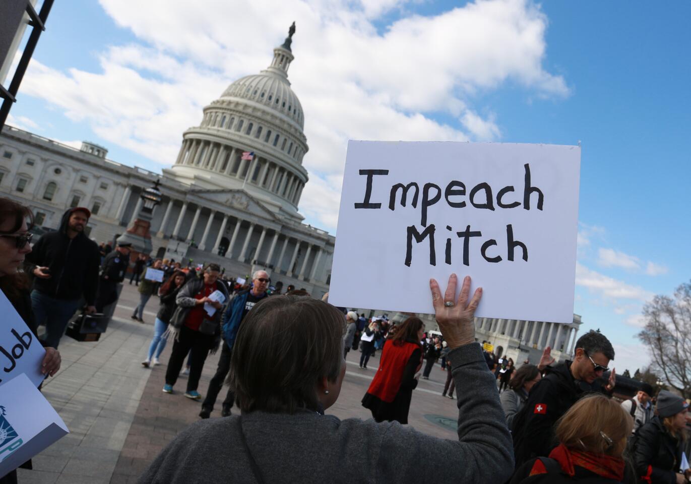 Demonstrators hold signs during the Senate impeachment trial of President Trump in Washington, D.C., on Wednesday.