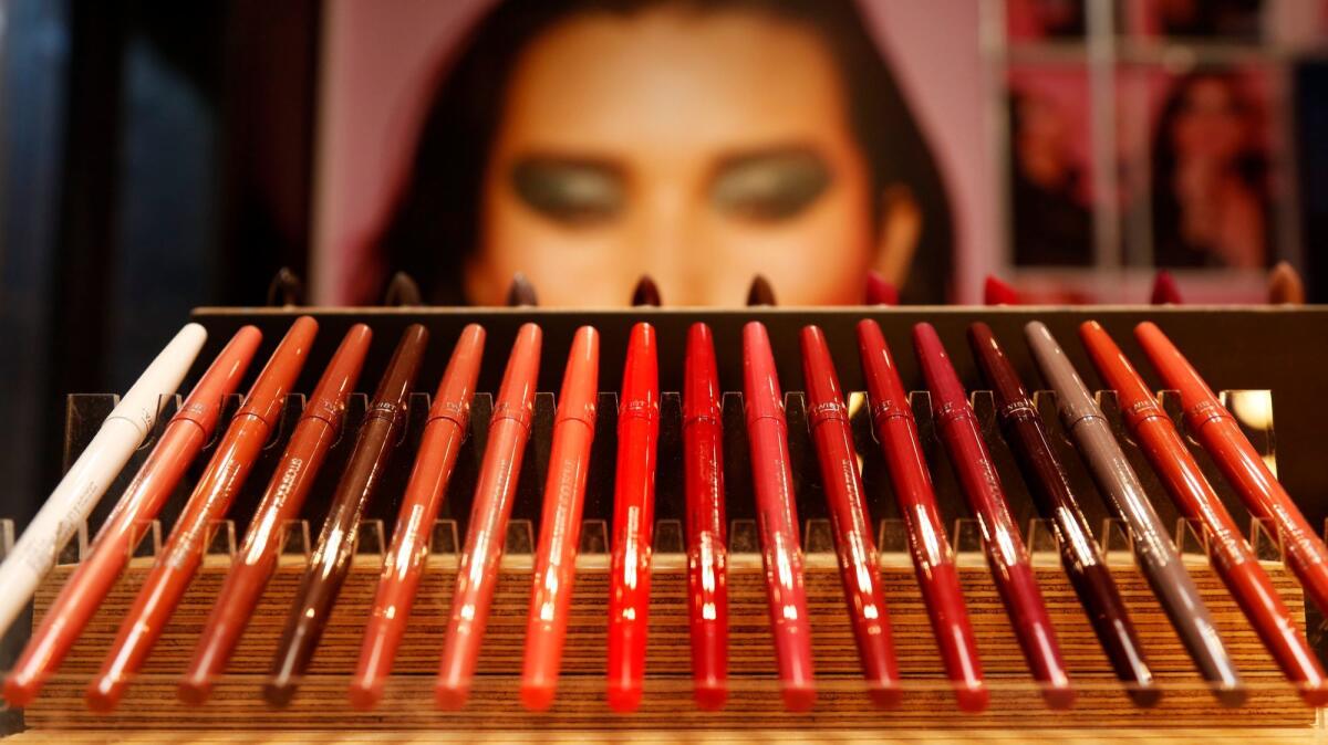 A photograph of a model peers behind a row of eyeliner pens inside the new Smashbox store in Venice. (Genaro Molina / Los Angeles Times)