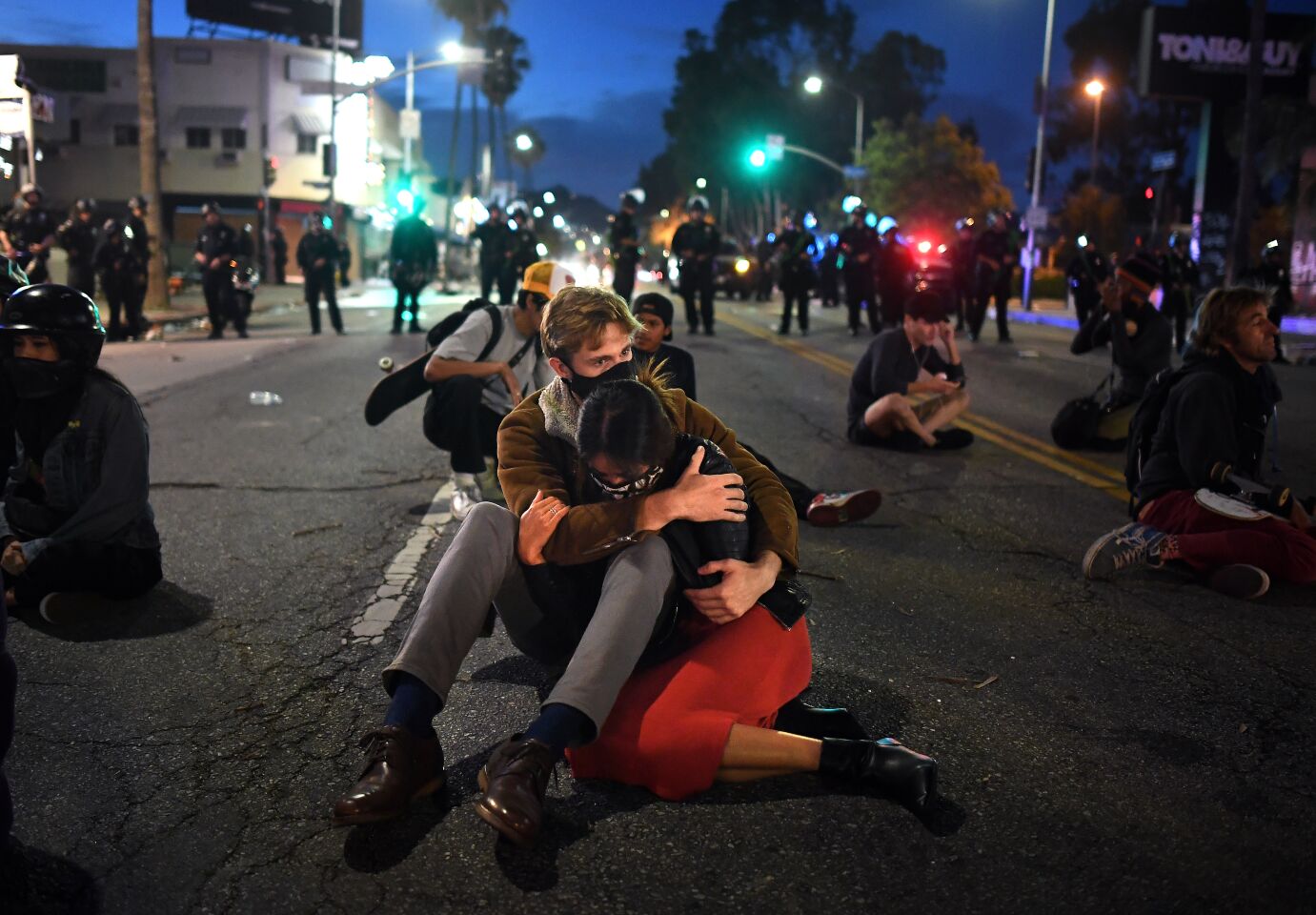 A couple of protesters embrace on Fairfax Avenue in Los Angeles Saturday.
