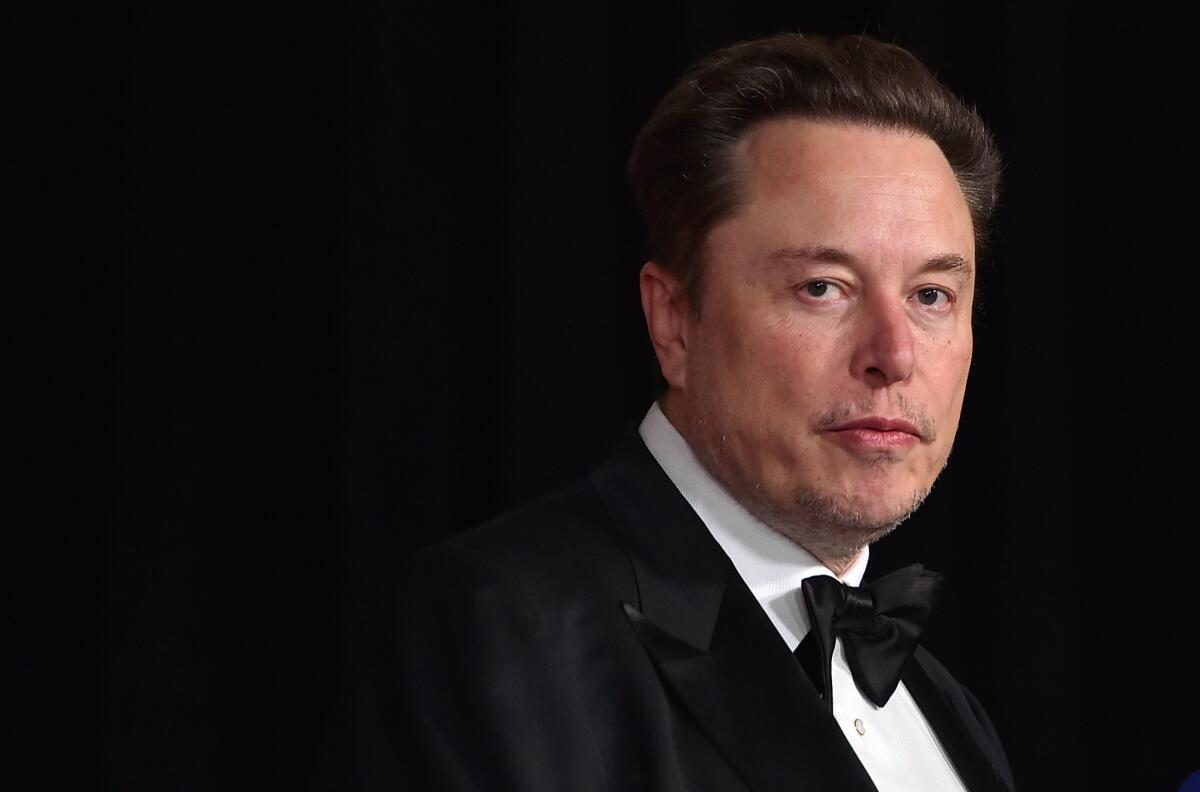 Elon Musk, in a black tux, looks into the camera.