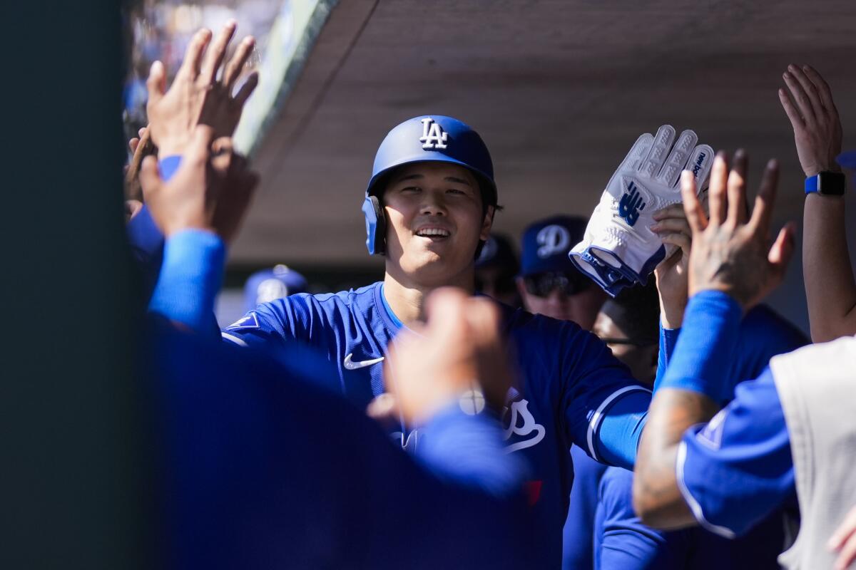 Dodgers designated hitter Shohei Ohtani celebrates in the dugout after scoring on a sacrifice fly.