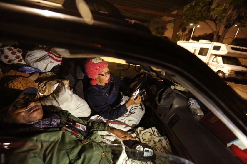 The McCues have been homeless for at least two years, living in their Jeep Grand Cherokee. Lawrence, 75, a Marine veteran who suffers from congestive heart failure and diabetes, beds down for the night as Carla, his 62-year-old wife, reads the Bible at SafeParking LA.