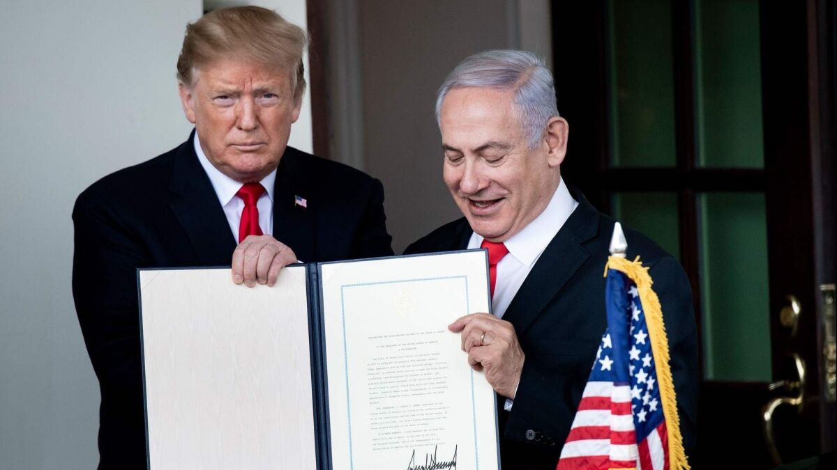 President Trump and Israel's Prime Minister Benjamin Netanyahu hold up a Golan Heights proclamation after a meeting in Washington on March 25.