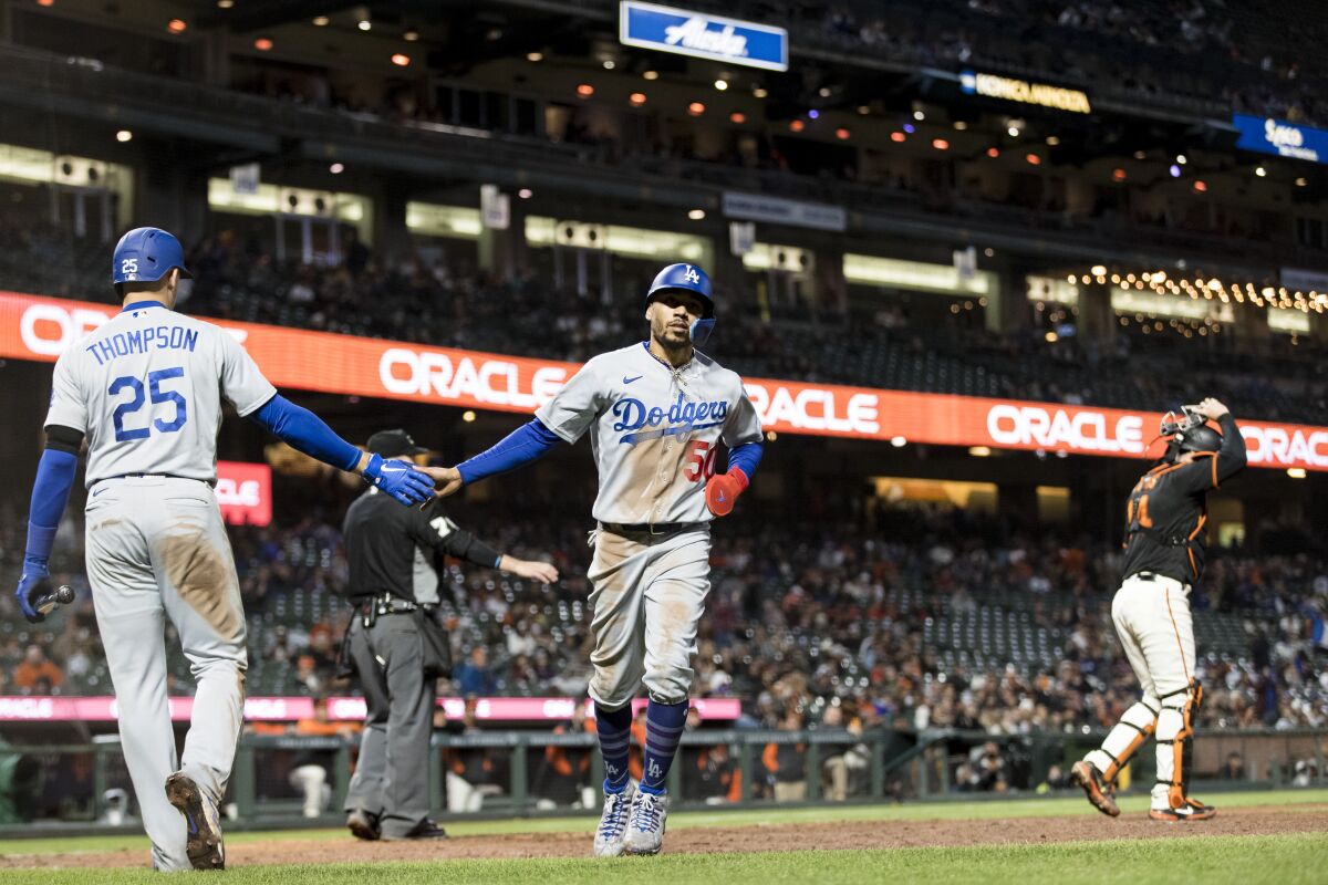 Mookie Betts, a la derecha, es felicitado por Trayce Thompson luego de anotar en la décima entrada.