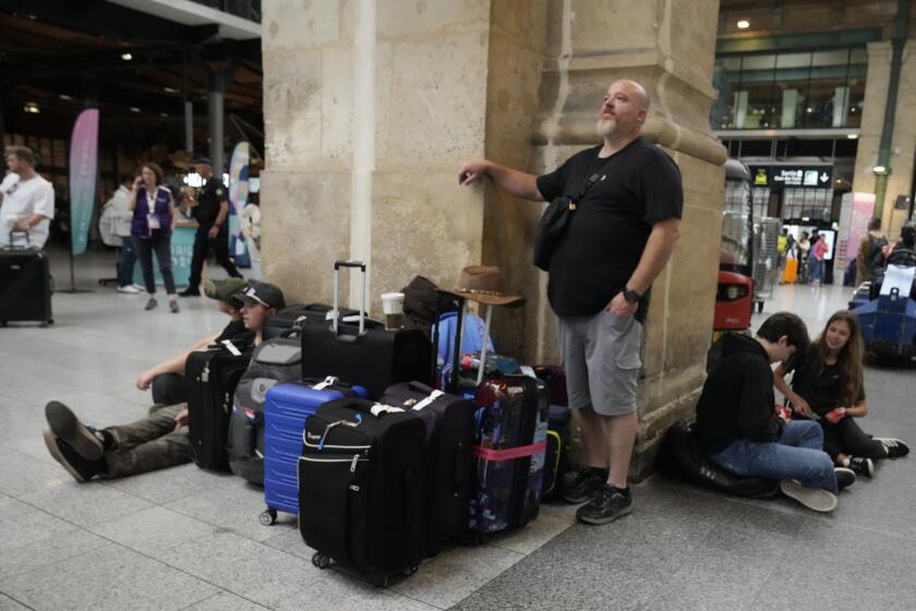 Travelers wait inside the Gare du Nord train station at the 2024 Summer Olympics, Friday, July 26, 2024, in Paris, France. Hours away from the grand opening ceremony of the Olympics, high-speed rail traffic to the French capital was severely disrupted on Friday by what officials described as "criminal actions" and sabotage. (AP Photo/Mark Baker)