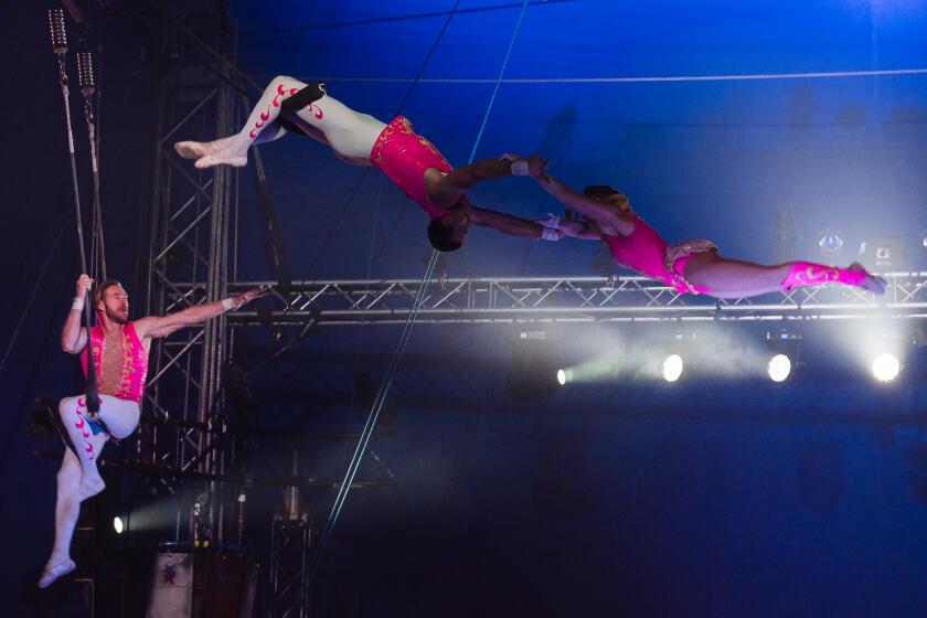 Trapeze Artists Cogi Haggerty (left) and Tad Payne-Tobin (center) perform at Circus Vargas in National City on February 4, 2022.