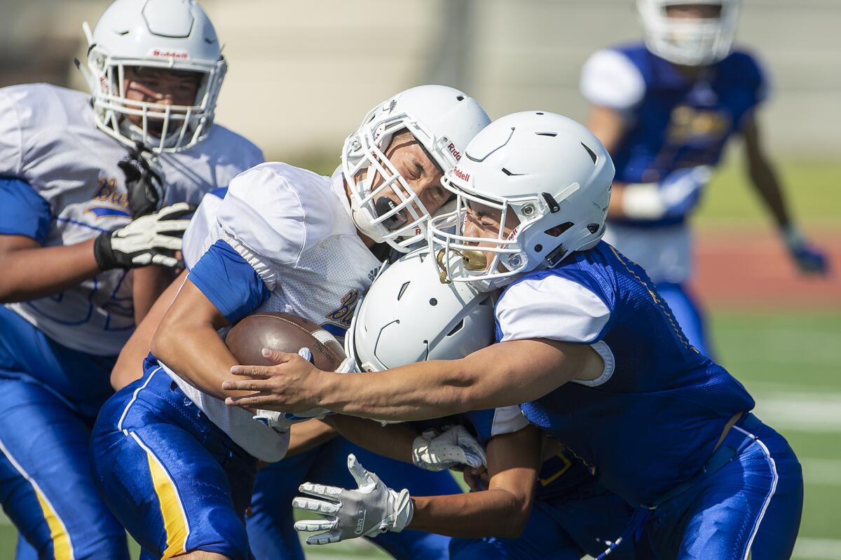 Fountain Valley's Jerry Ngo, right, tackles Nathan Le, left, during practice on Aug. 8.