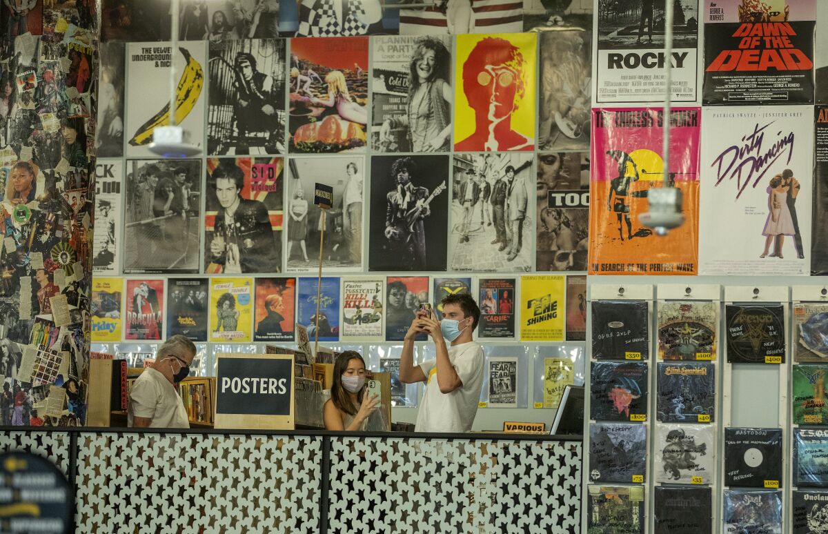 Customers photograph posters on display inside Amoeba Music in Hollywood