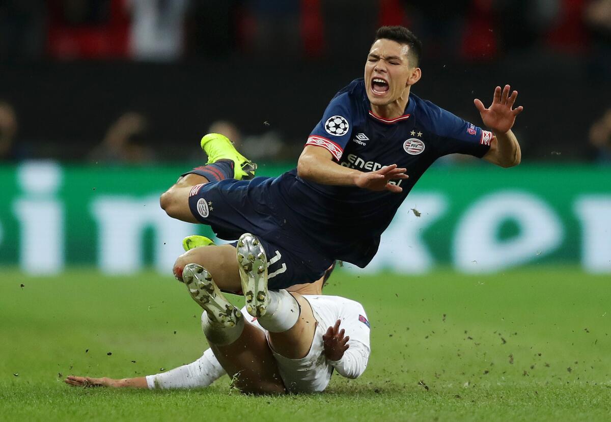 Hirving Lozano of PSV Eindhoven is tackled by Heung-Min Son of Tottenham Hotspur during the Group B match of the UEFA Champions League between Tottenham Hotspur and PSV at Wembley Stadium on November 6, 2018 in London, United Kingdom.