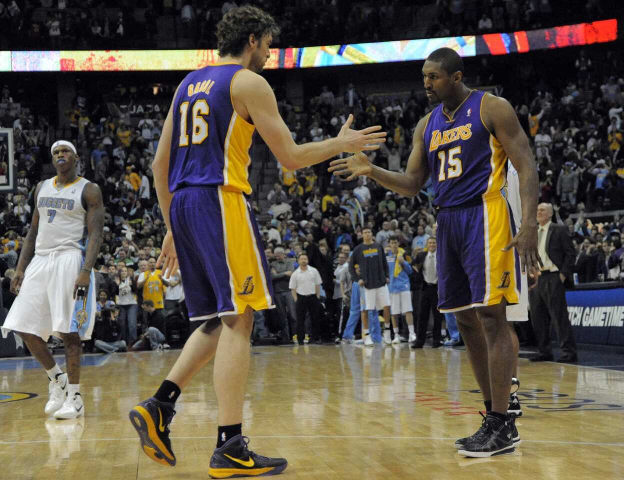 Lakers forwards Pau Gasol and Metta World Peace celebrate a basket against the Nuggets in the fourth quarter Friday night at the Pepsi Center in Denver.
