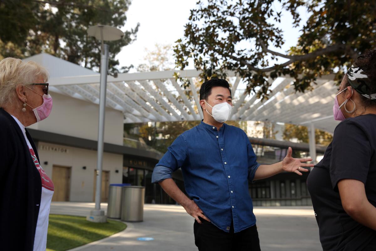 L.A. City Councilman David Ryu speaks with Renee Weitzer, left, and Sabra Williams at the Hollywood Bowl Vote Center.