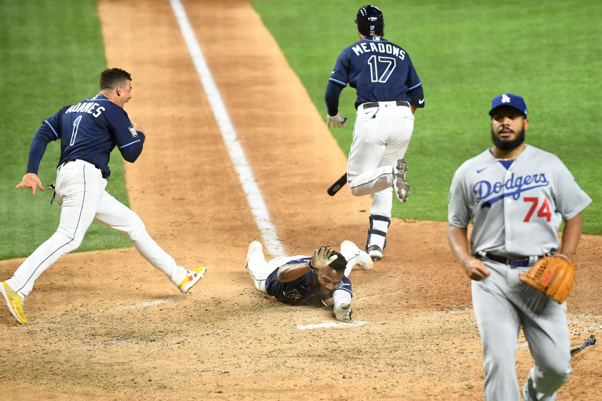 Tampa Bay's Randy Arozarena pounds home plate after sliding in to score the winning run.