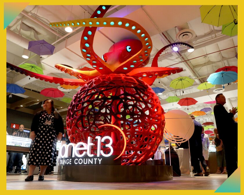 People mill about behind and near a 16-foot-tall animatronic octopus