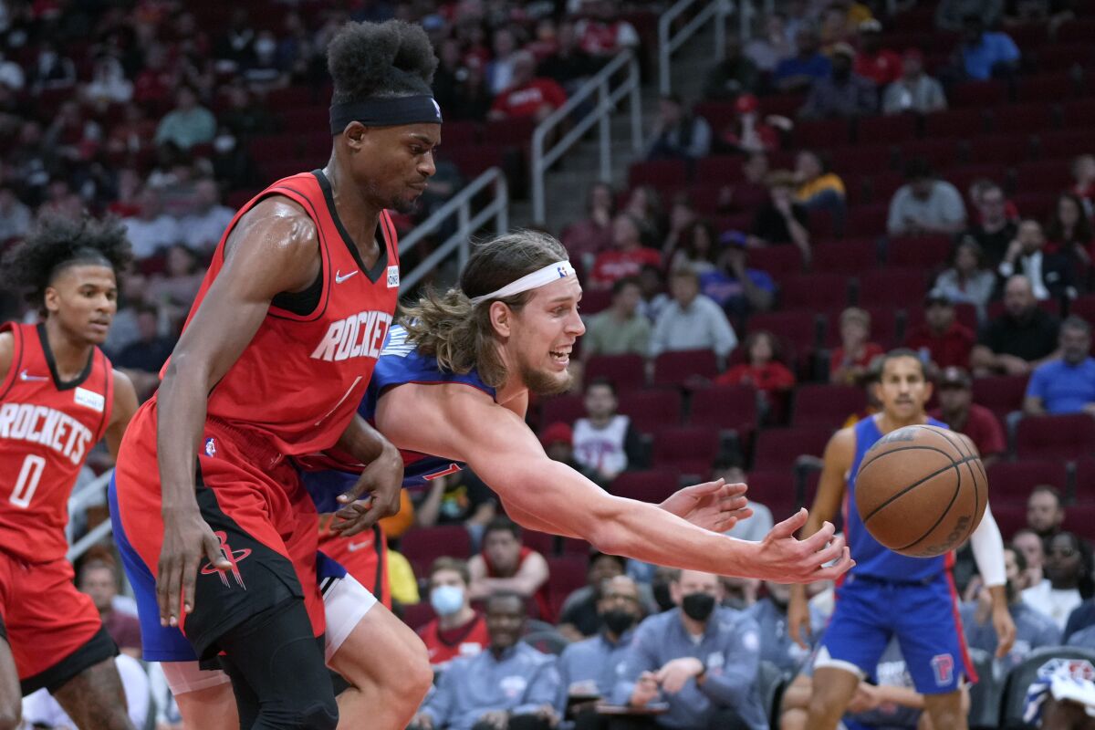 Detroit Pistons forward Kelly Olynyk, right, tries to save the ball from going out of bounds as Houston Rockets forward Danuel House Jr. defends during the first half of an NBA basketball game Wednesday, Nov. 10, 2021, in Houston. (AP Photo/Eric Christian Smith)