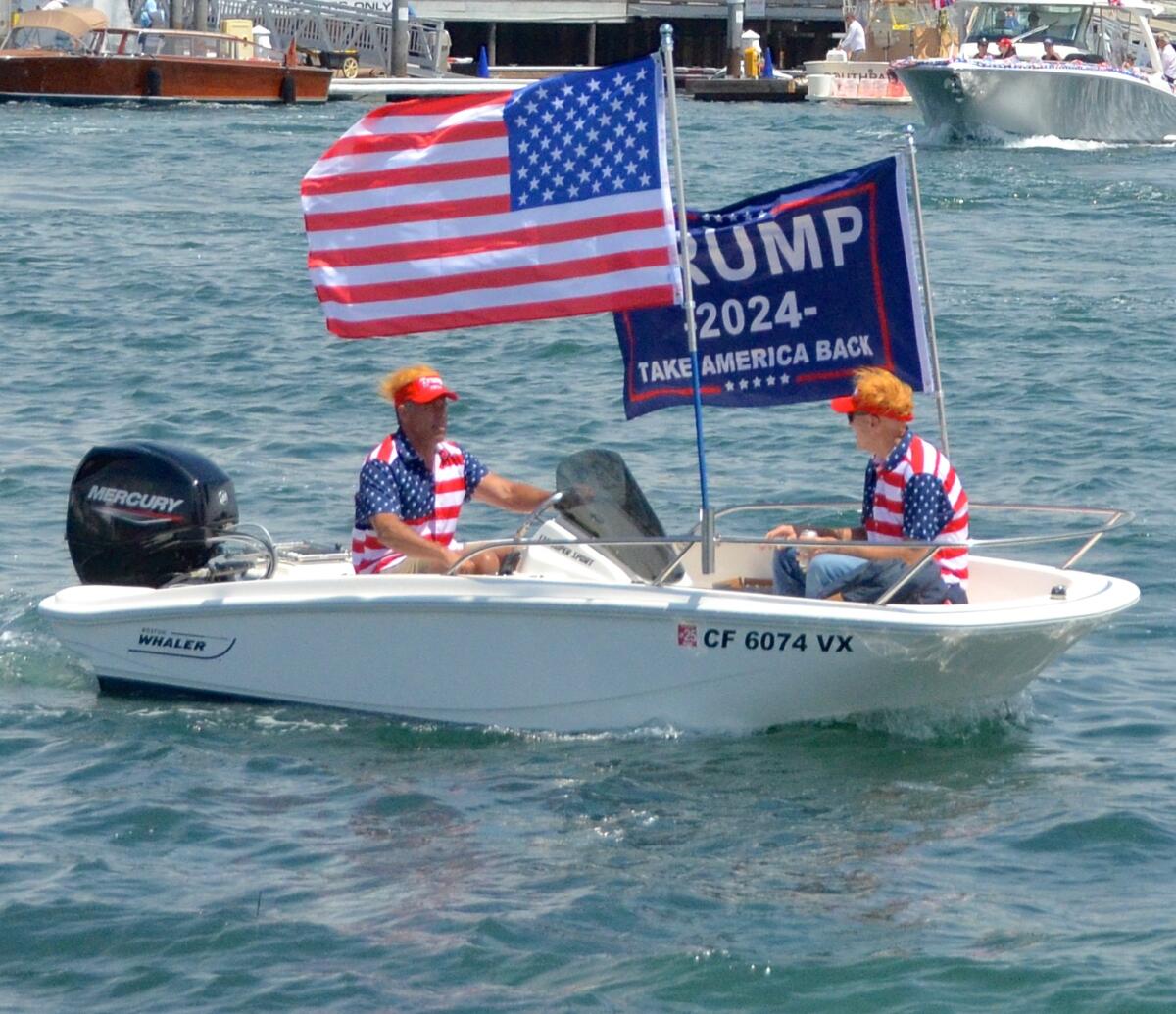 Two carrot-top sailors in a Boston Whaler cruised in the Trumptilla parade Sunday in Newport Harbor.