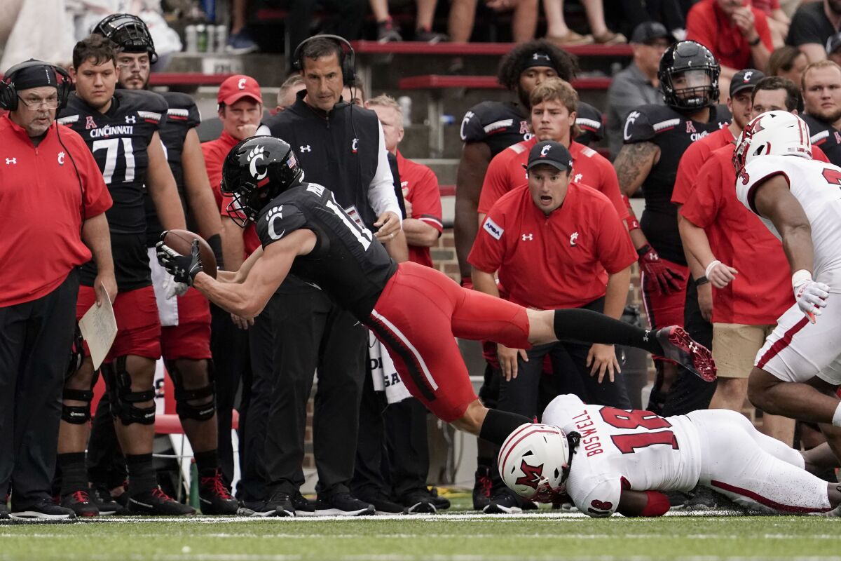 Cincinnati wide receiver Alec Pierce (12) is tackled by Miami (Ohio) defensive back Cedric Boswell (18) during the second half of an NCAA college football game Saturday, Sept. 4, 2021, in Cincinnati. (AP Photo/Jeff Dean)