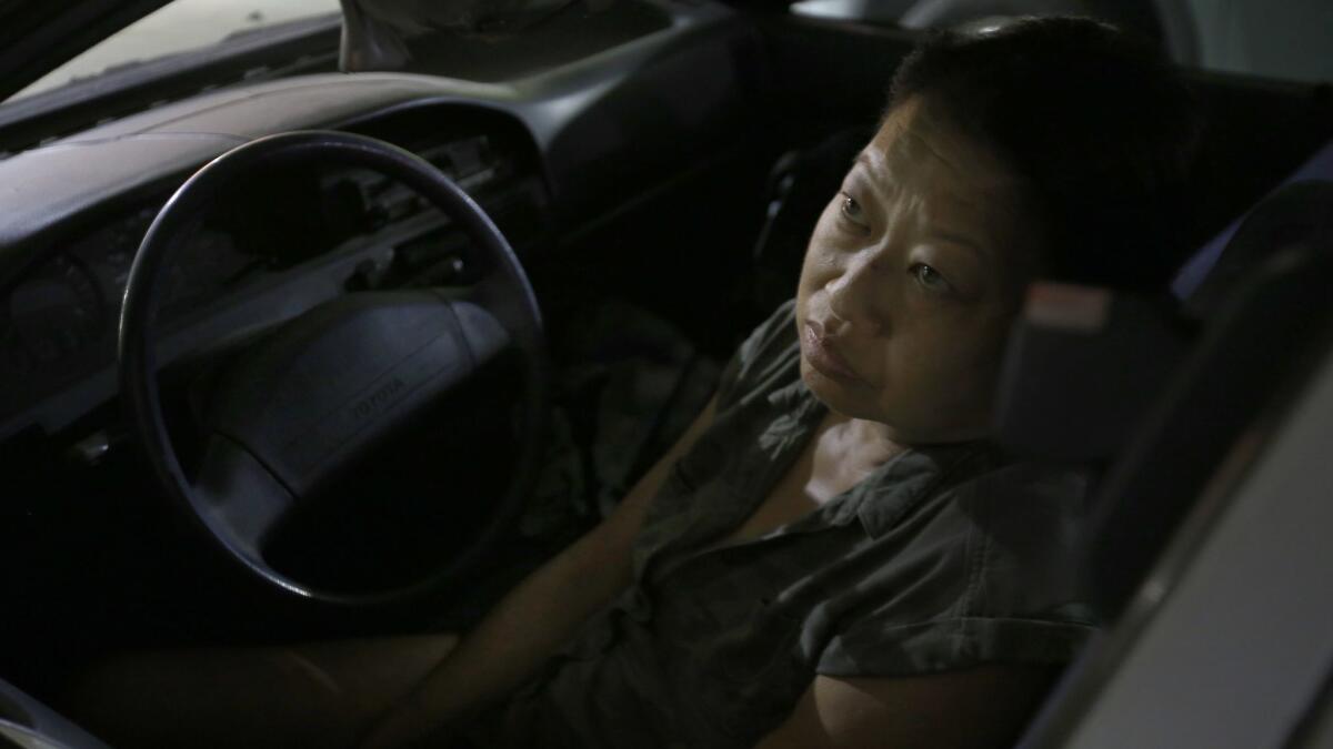 Meg Shimatsu sits in her car in Glendale in August 2017. Formerly homeless, she has just received a place to live.