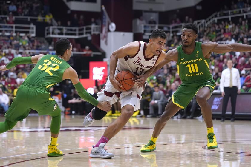 Stanford forward Oscar da Silva (13) dribbles past Oregon guard Anthony Mathis (32) and forward Shakur Juiston (10) during the second half of an NCAA college basketball game Saturday, Feb. 1, 2020, in Stanford, Calif. Stanford won 70-60. (AP Photo/Tony Avelar)