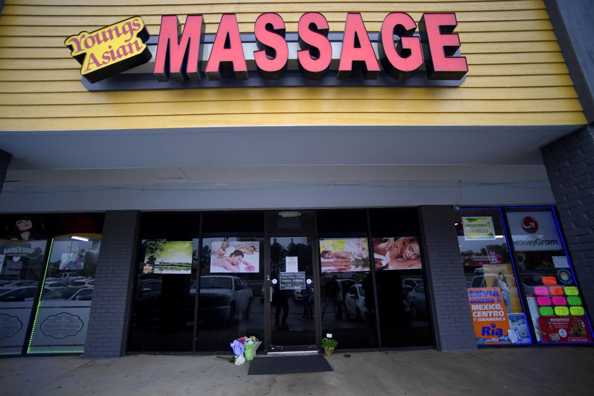 Flower bouquets sit outside a business with a sign "Youngs Asian Massage."