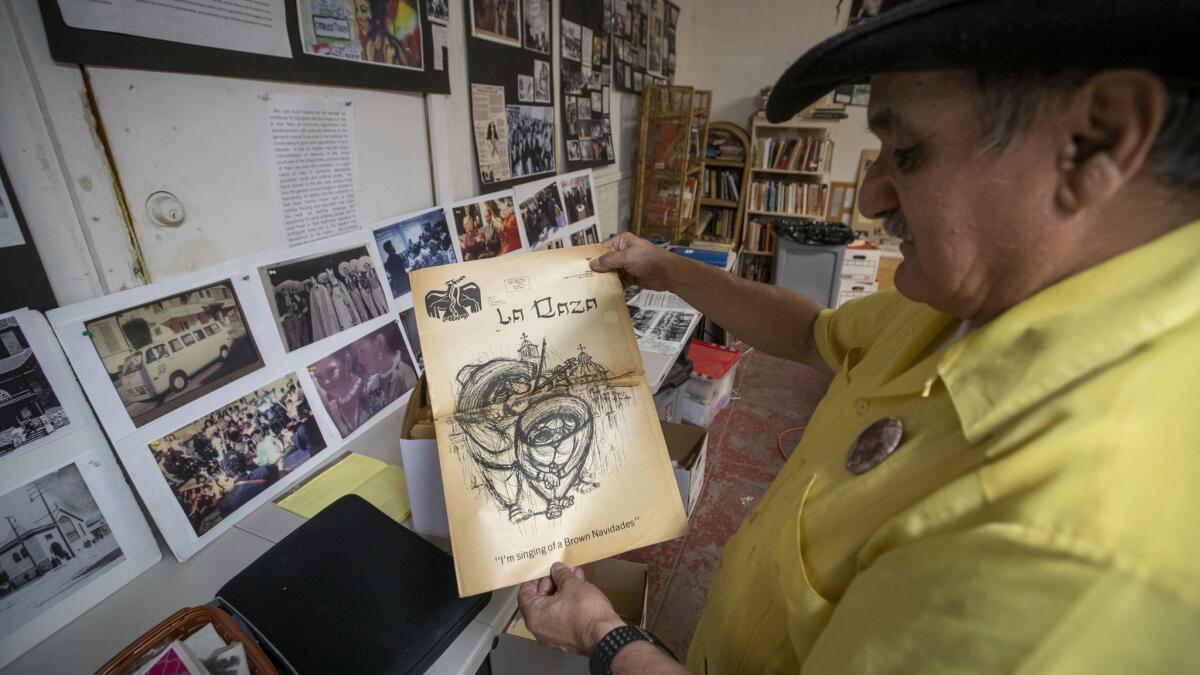 Rosalio Muñoz, director of the Epiphany people's history project, holds a 1970 copy of the newspaper La Raza, a bilingual newspaper and magazine published by Chicano activists in the basement of The Church of the Epiphany in Lincoln Heights.