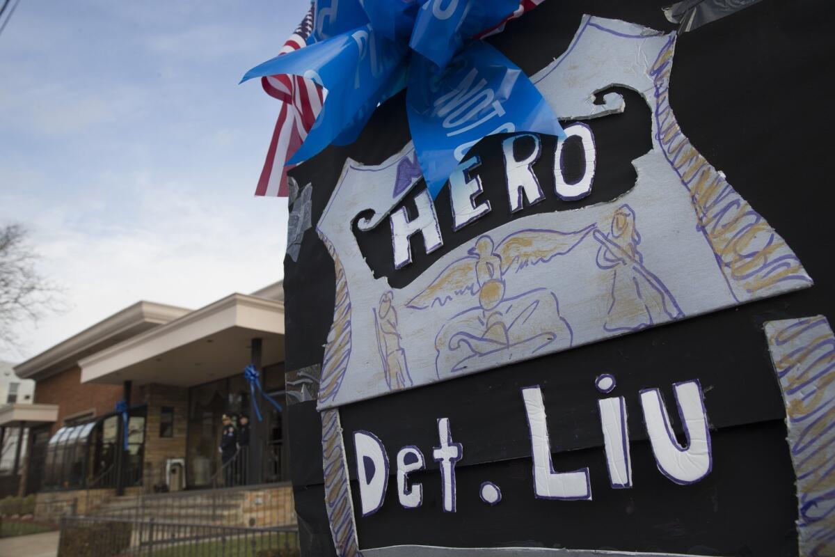 A sign praising Officer Wenjian Liu hangs outside Aievoli Funeral Home before his wake on Saturday in Brooklyn. Liu and his partner, Officer Rafael Ramos, were killed Dec. 20 as they sat in their patrol car.