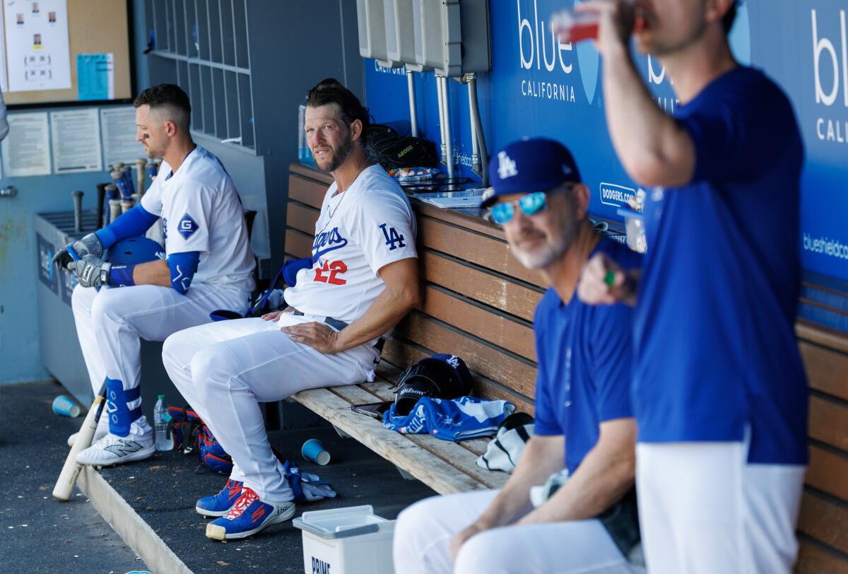 Dodgers starter Clayton Kershaw, second from left, sits in the home dugout with other team members