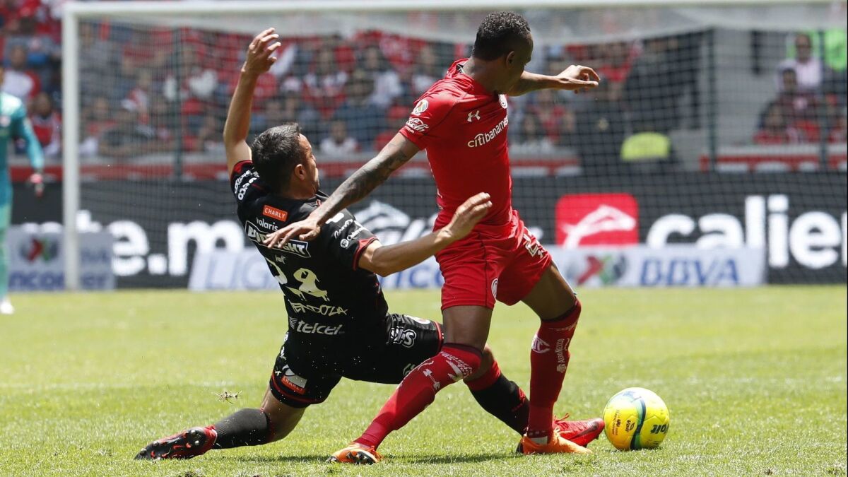 Tijuana's Omar Mendoza (left) maneuvers for control of the ball against Toluca's Luis Quinones during Tijuana s 4-1 loss in the Liga MX semis last spring.
