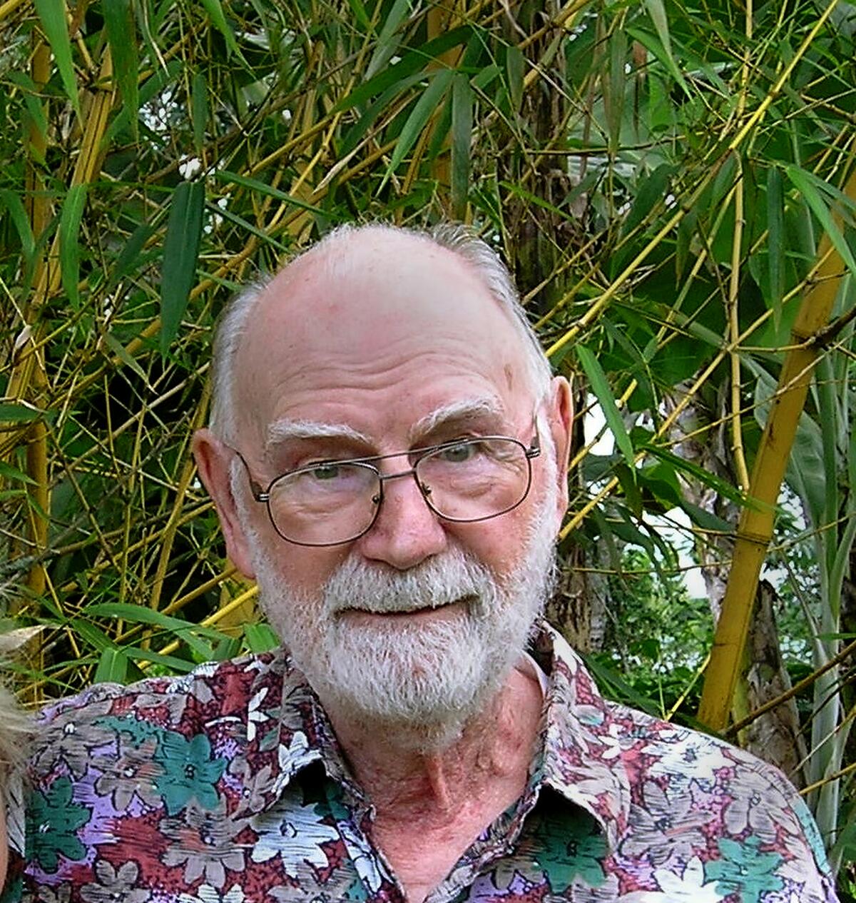 John Garvison poses in front of a wall plants outdoors. 