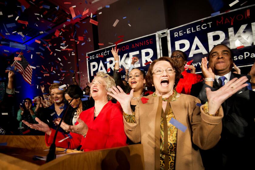 Houston Mayor Annise Parker, center, celebrates her election victory with her partner, Kathy Hubbard, right, during a campaign party at the George R. Brown Convention Center in Houston.