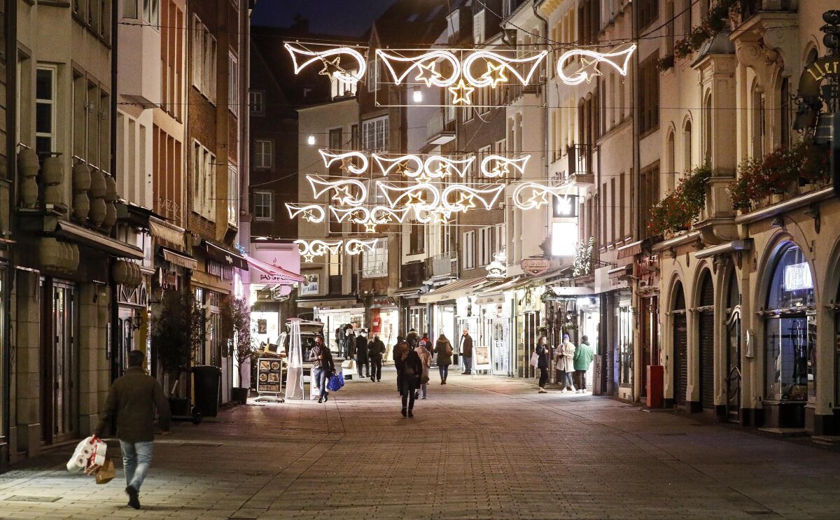 Christmas lights shine over a virtually empty shopping street in Dusseldorf, Germany, on Monday.
