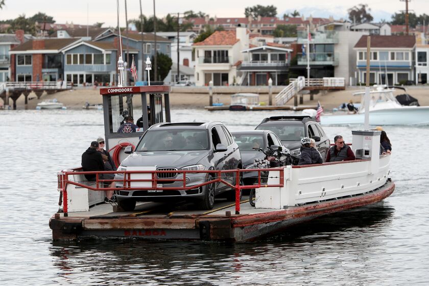 The Balboa Island Ferry transports vehicles and pedestrians from Balboa Island to Balboa Peninsula on Saturday in Newport Beach.