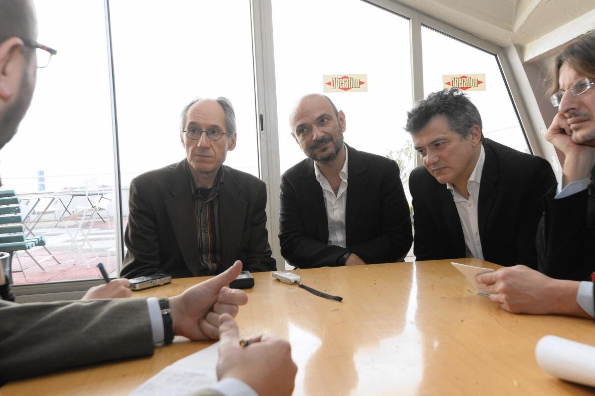 From left, Charlie Hebdo's editor-in-chief, Gerard Biard, lawyer Richard Malka and columnist Patrick Pelloux talk to reporters at the offices of the French newspaper Liberation, where the Charlie staff is preparing its upcoming edition.