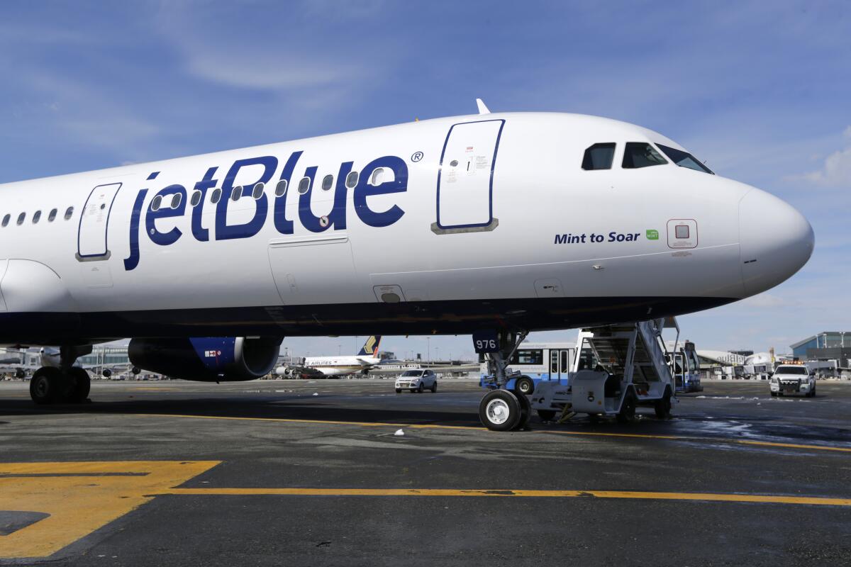 FILE- In this March 16, 2017, file photo, a Jet Blue airplane at John F. Kennedy International Airport in New York. JetBlue is staying in the Big Apple. The airline said Tuesday, Aug. 3, 2021 that it will keep its headquarters in New York and expand its flagship terminal at JFK Airport. (AP Photo/Seth Wenig, File)