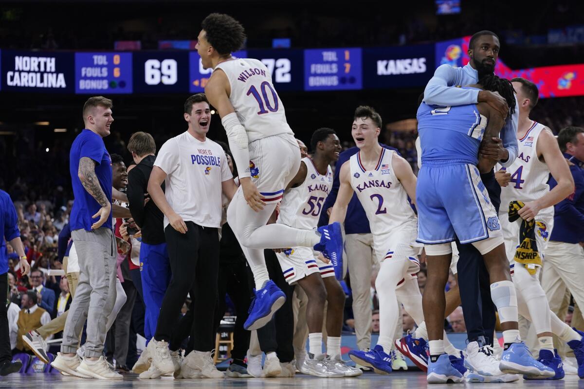 North Carolina guard Caleb Love, right, reacts to a loss as Kansas' Jalen Wilson (10) celebrates after a college basketball game in the finals of the Men's Final Four NCAA tournament, Monday, April 4, 2022, in New Orleans. Kansas won 72-69. (AP Photo/David J. Phillip)