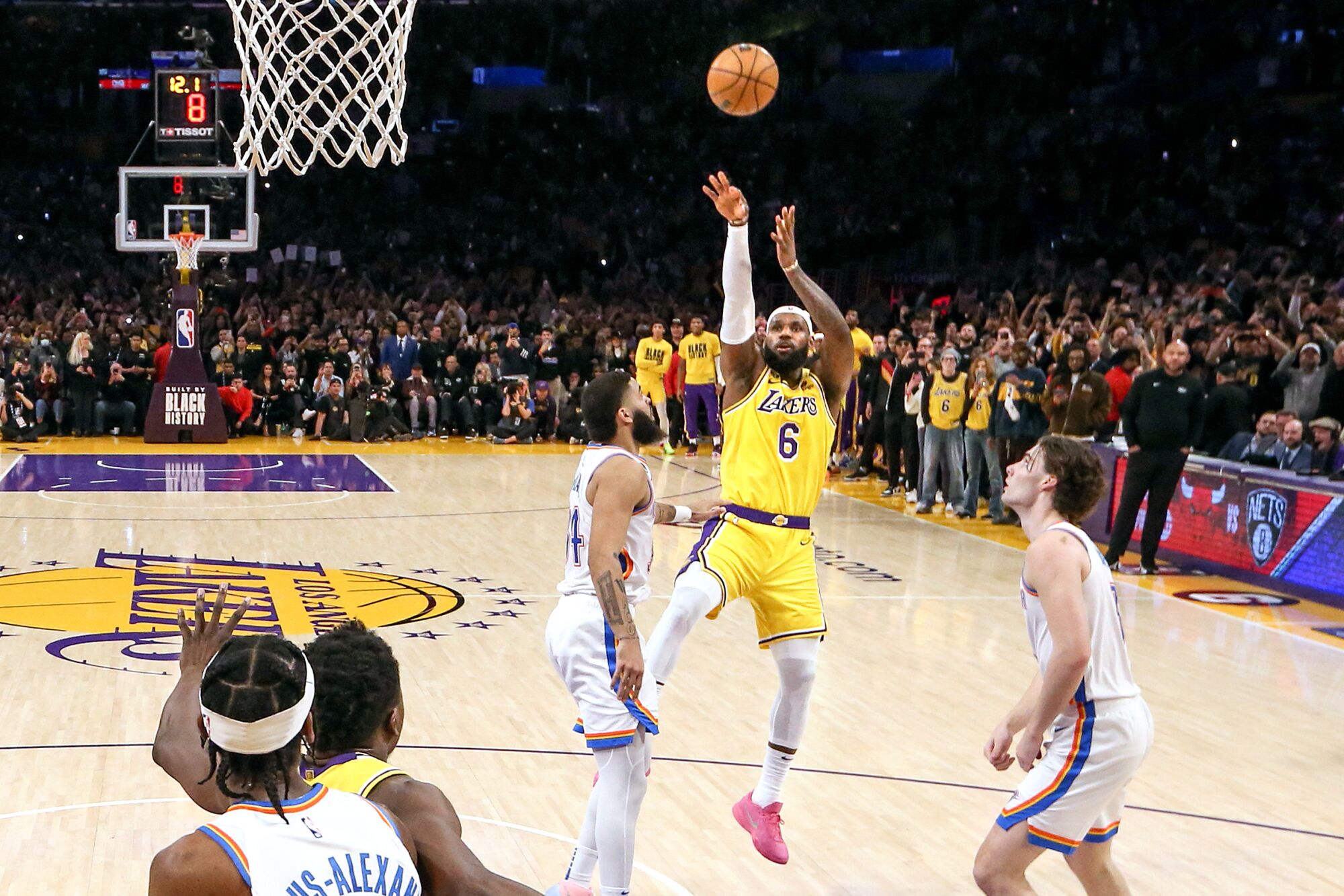 Full-body view of LeBron James midair with the basketball leaving his hands as he scores his 38,388th career point.