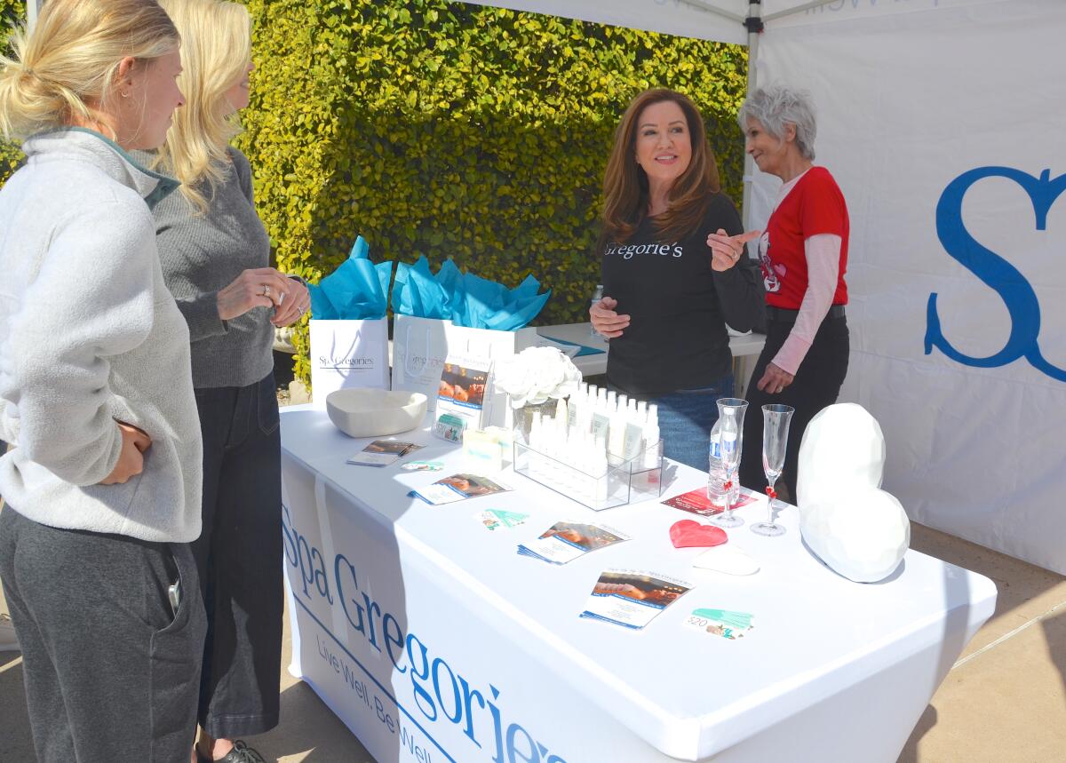 Spa Gregorie co-owner Itica Milanes-Duncan, center, speaks to attendees as Karen Lunzman assists.