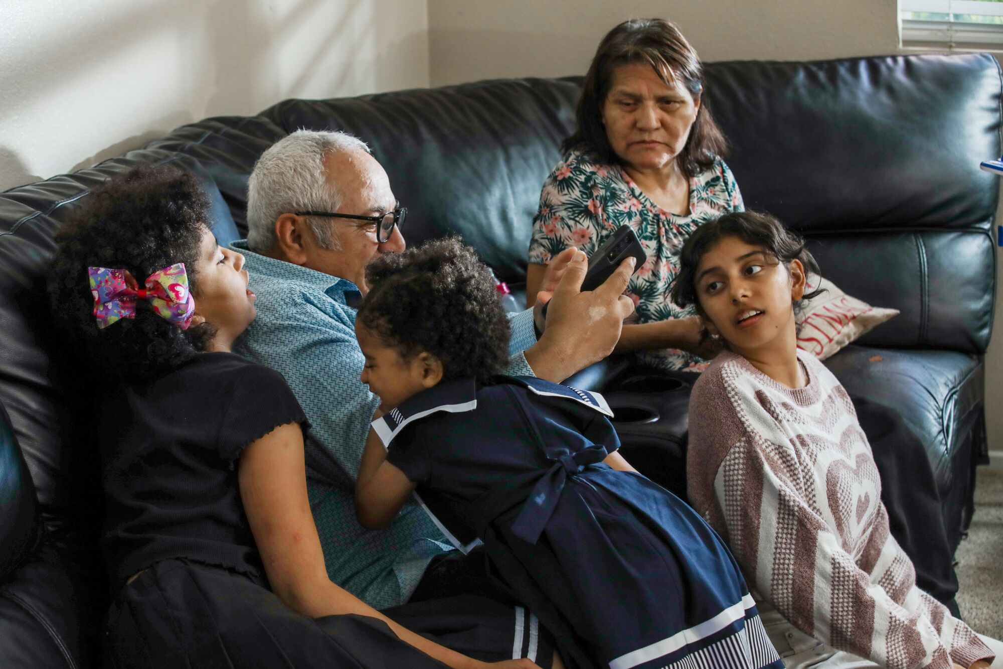 Children surround their grandparents on a couch