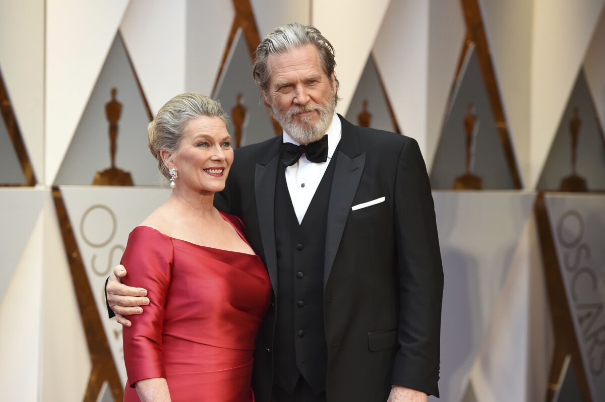 Susan Geston, left, and Jeff Bridges arrive at the Oscars on Sunday, Feb. 26, 2017, at the Dolby Theatre in Los Angeles. Bridges announced on his website Monday, Sept. 13, 2021 that his cancer was in remission and that he and his wife Susan Geston also recovered from COVID-19. (Photo by Jordan Strauss/Invision/AP)