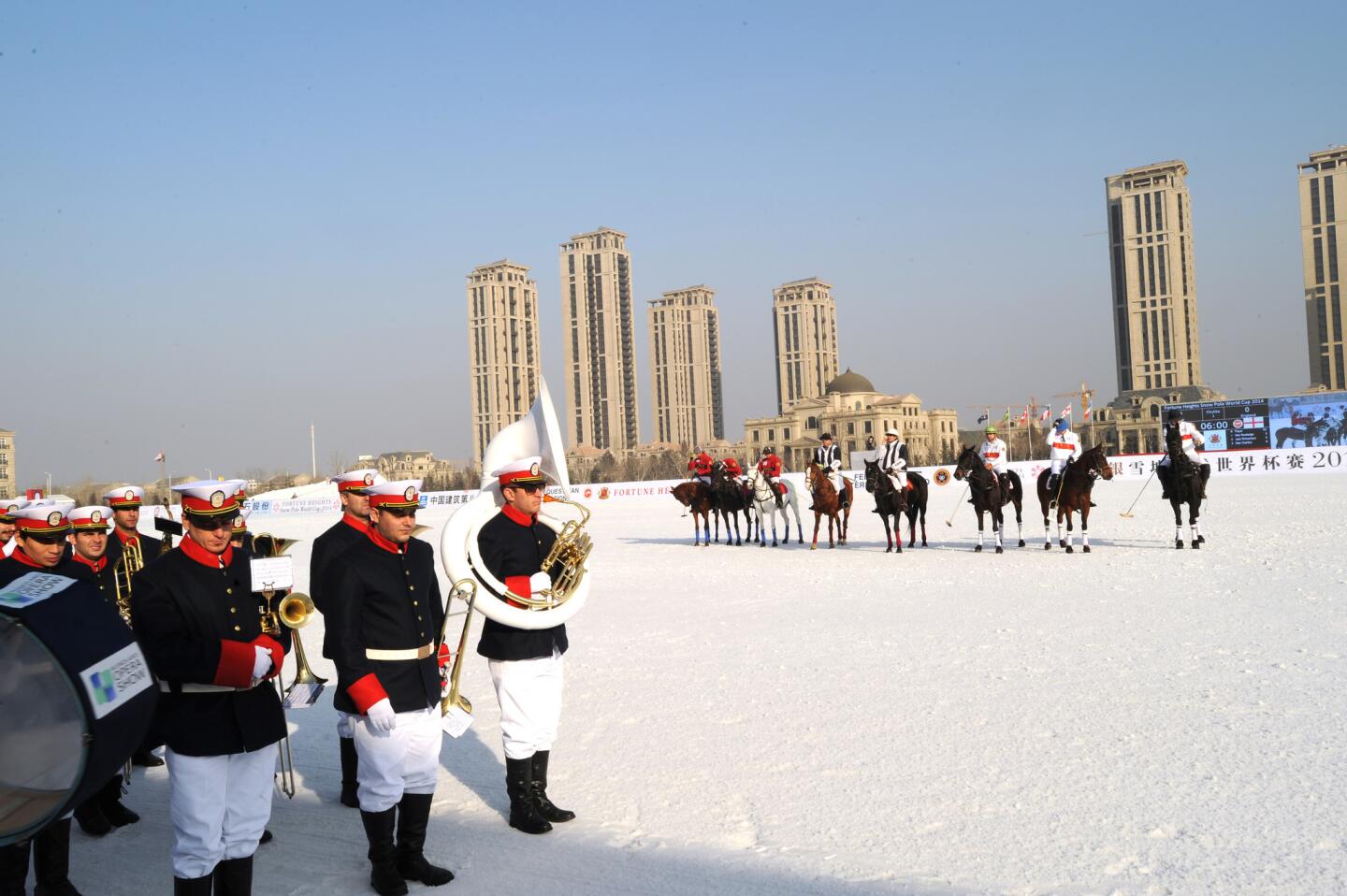 Polo players watch as the Buenos Aires Marching Band prepares to perform during the halftime action at the Snow Polo World Cup, held in Tianjin, China.