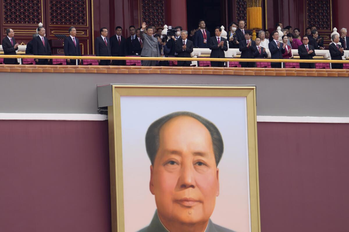 Chinese President Xi Jinping, center, waves above a large portrait of the late leader Mao Zedong during a ceremony to mark the 100th anniversary of the founding of the ruling Chinese Communist Party at Tiananmen Gate in Beijing Thursday, July 1, 2021. Artillery roared, bands played and fighter jets soared overhead as thousands gathered in Beijing’s iconic Tiananmen Square for a ceremony marking the centenary of the ruling Communist Party. Meanwhile, Hong Kong held its own annual commemorations of the 1997 handover from British to Chinese rule, given added significance by the party centenary and the arrests of political activists and journalists under a sweeping national security law imposed last year. (AP Photo/Ng Han Guan)