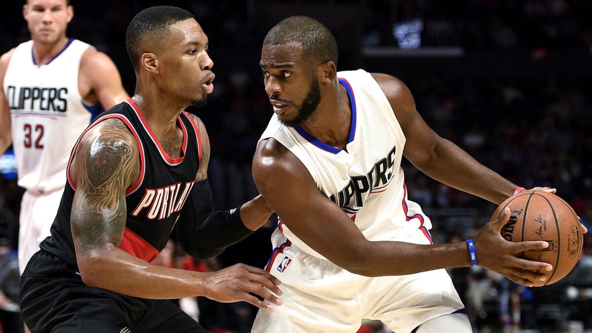 Clippers point guard Chris Paul protects the ball against the defense of Trail Blazers point guard Damian Lillard during an Oct. 22 exhibition game at Staples Center.