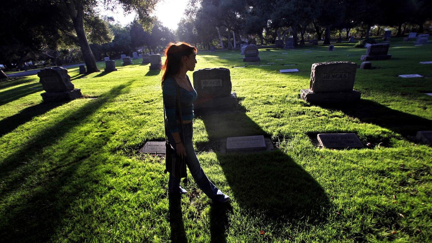 Yvonne Rojas visits the Oak Park Cemetery in Claremont, which has changed sprinkler heads and shortened watering times in its efforts to maintain the green grass during the drought.