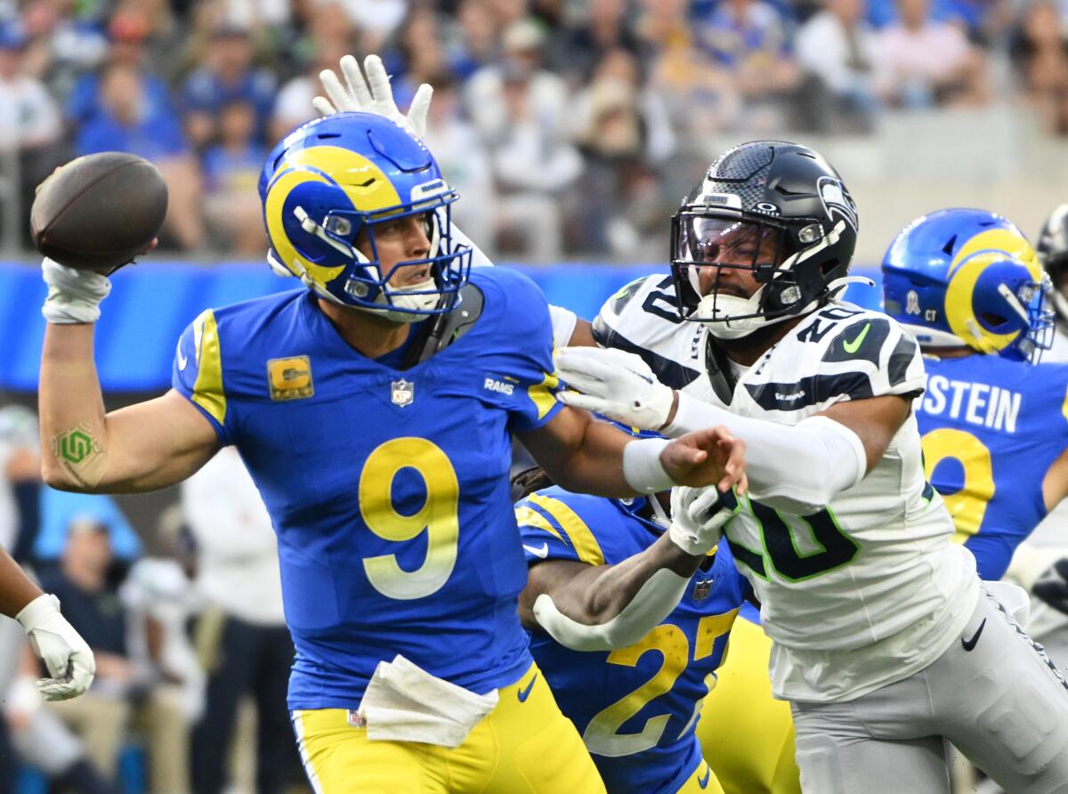 Rams' Matthew Stafford is pressured by Seattle Seahawks' Julian Love.