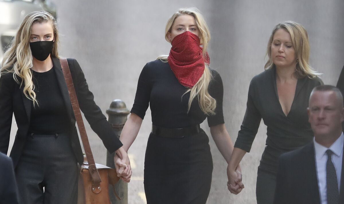 Actress Amber Heard, center, arrives at the High Court in London.