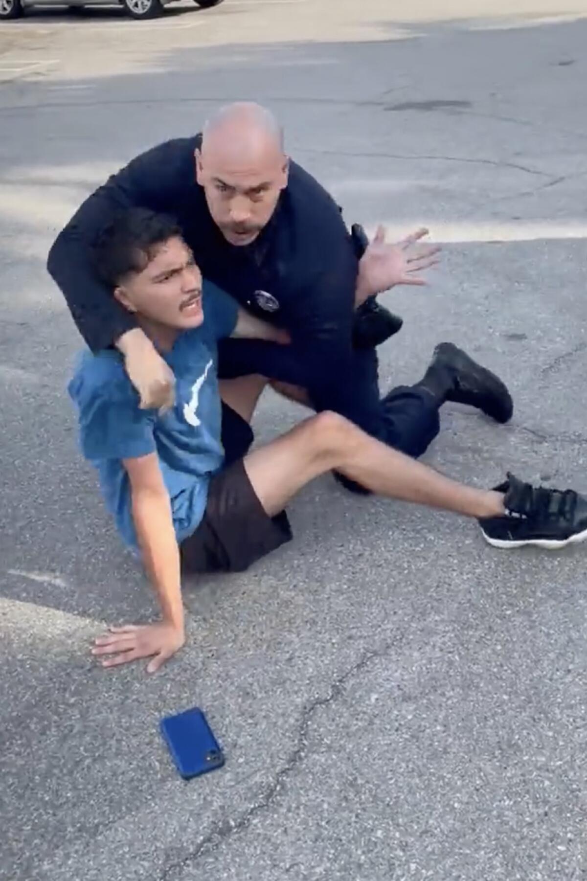 An unidentified Los Angeles police officer forcibly arrests Roberto Cortez 