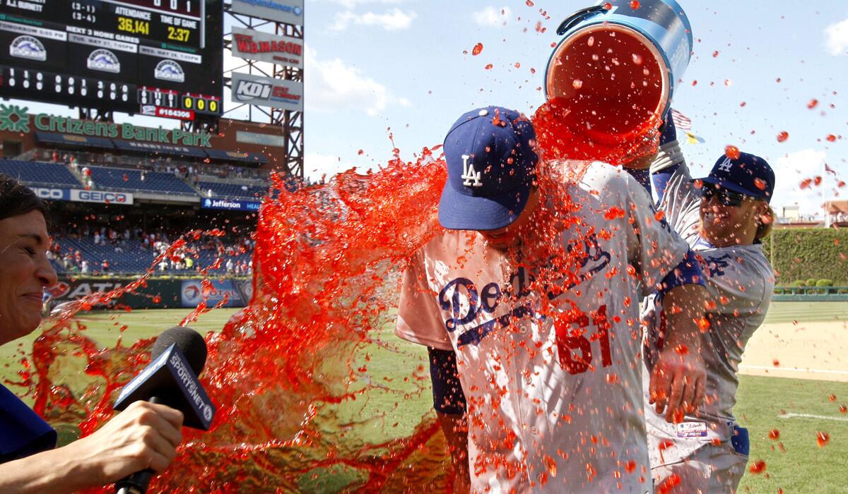 Josh Beckett gets a Gatorade bath from Dodgers teammate Justin Turner while doing a TV interview after pitching a no-hitter against the Phillies on Sunday in Philadelphia.